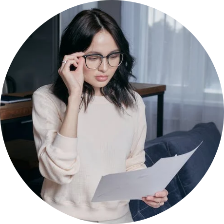 Woman reading paper and touching her glasses