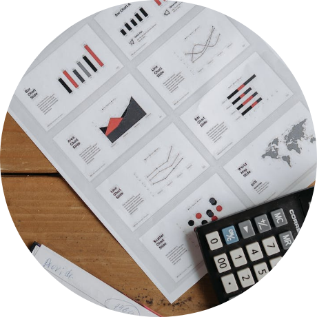 Orange and black charts on paper with calculator on top