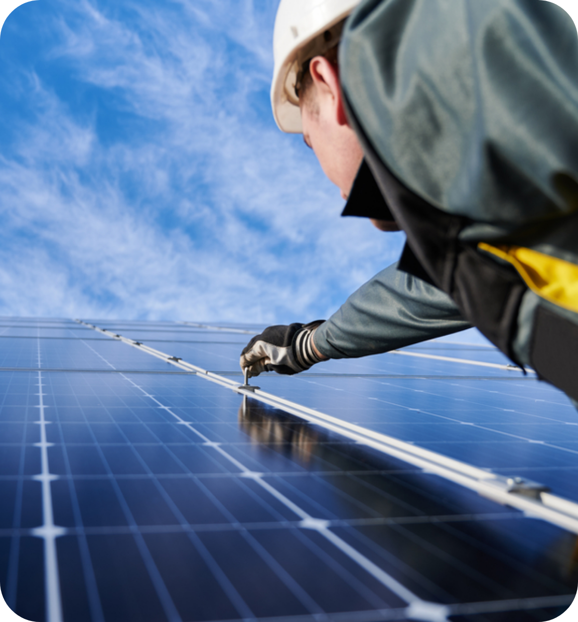 Maintenance worker reaching up to work on solar panels