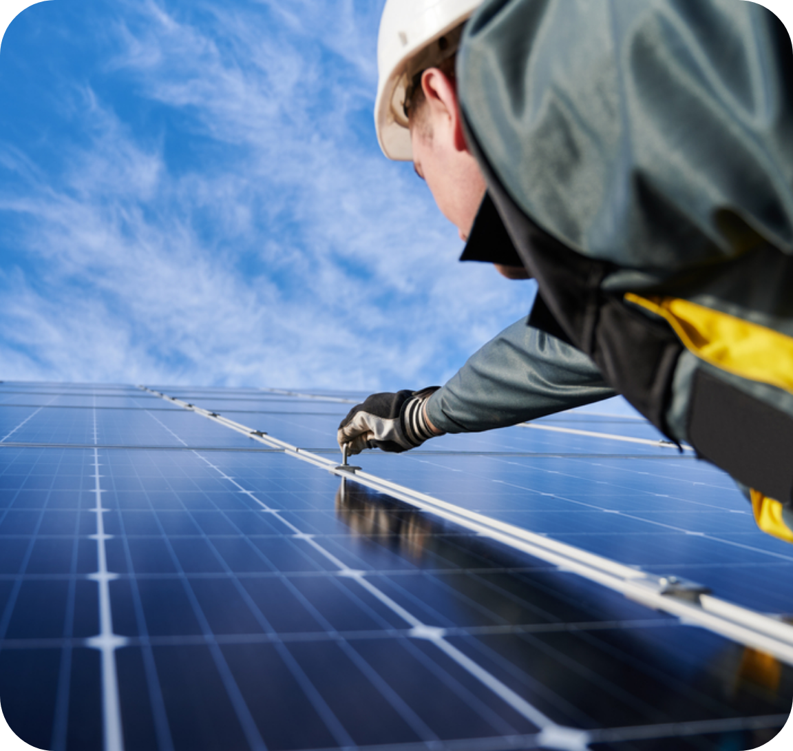 Maintenance worker reaching up to work on a solar panel