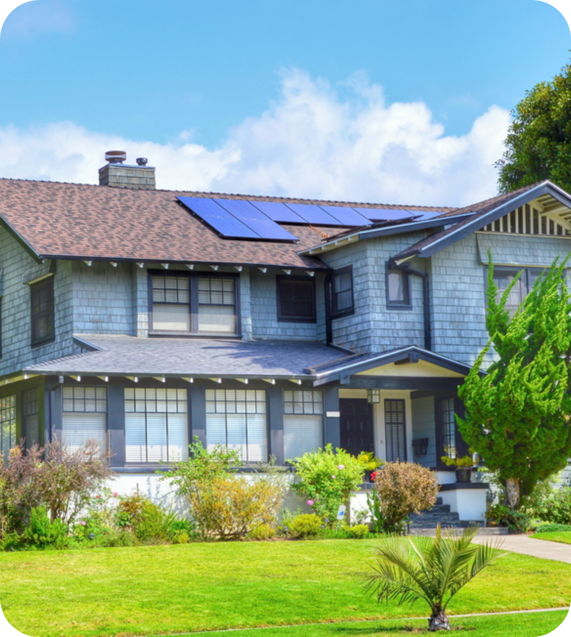 2 story house with solar panels and a tree in front