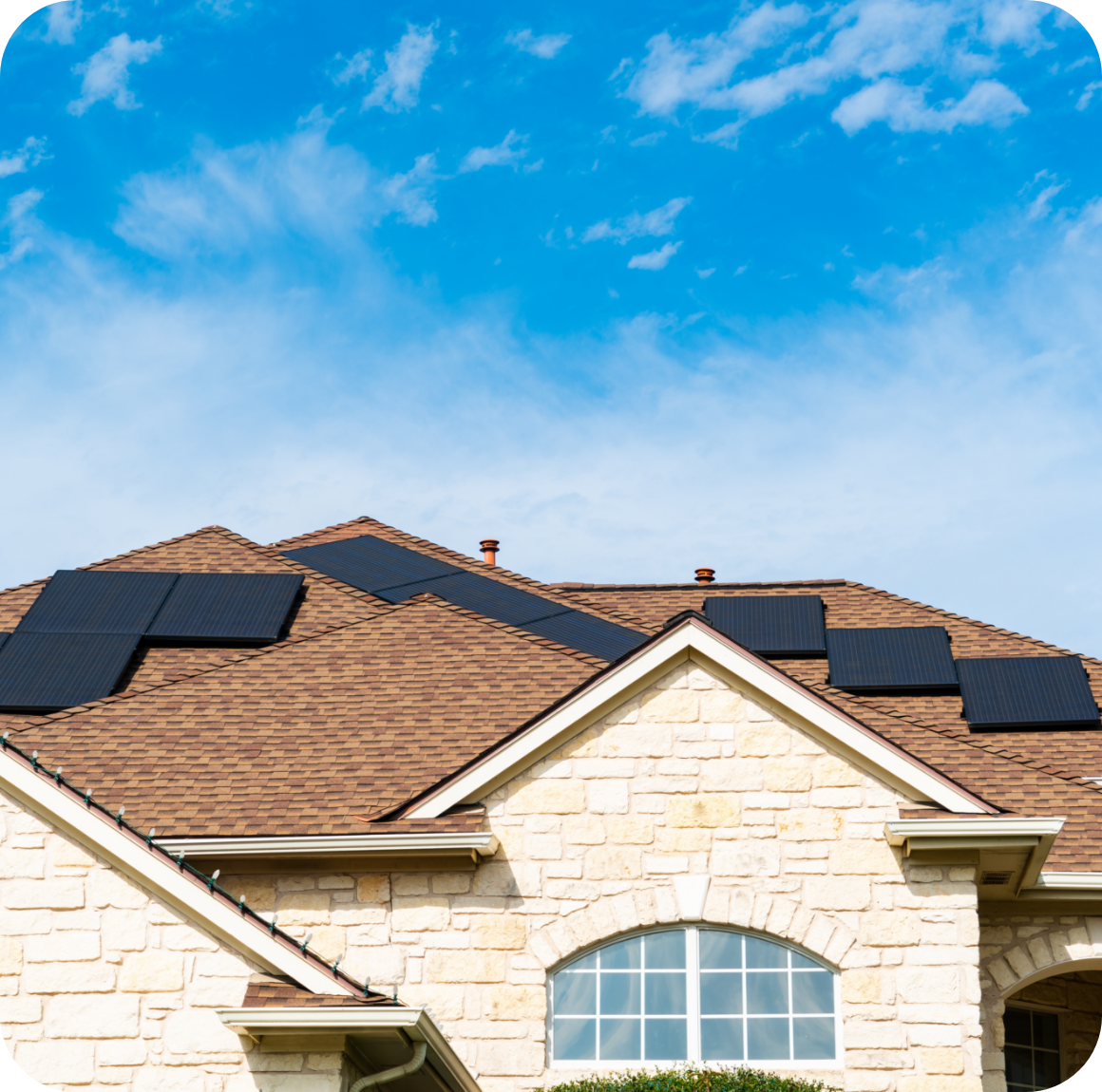 Cream brick house with a brown roof and solar panels