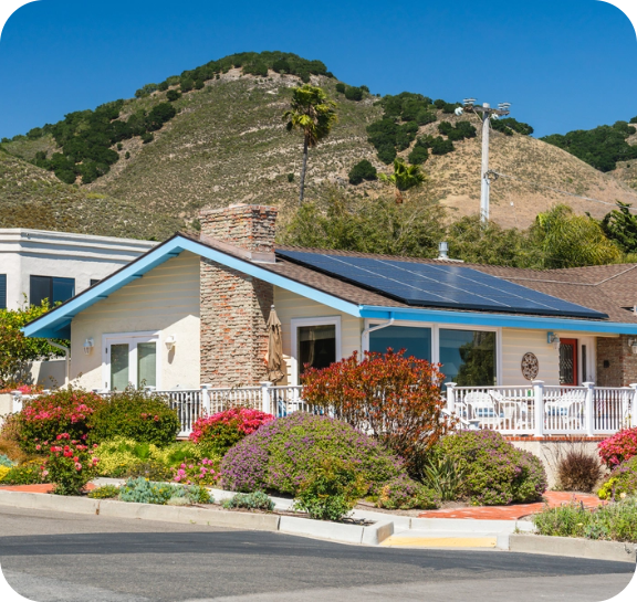 White house, with blue trim for the roof, solar panels, and a chimney