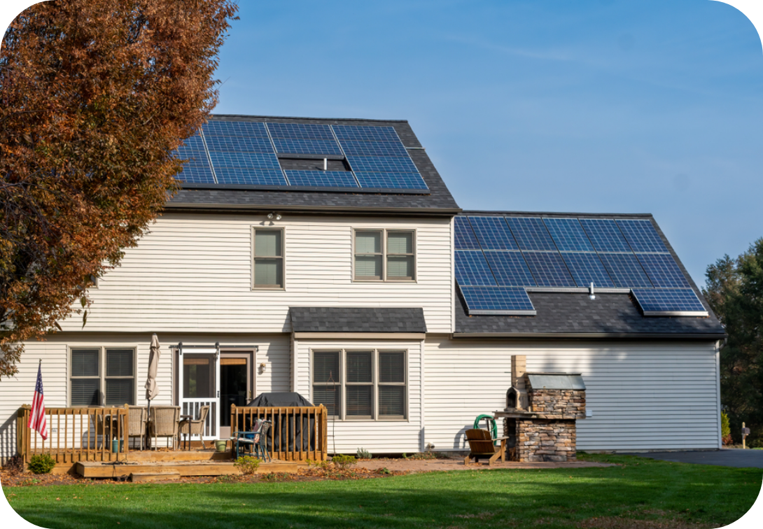 2 story house with solar panels and a wooden deck