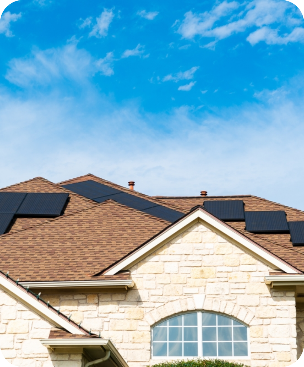 White brick house with brown shingles and solar panels