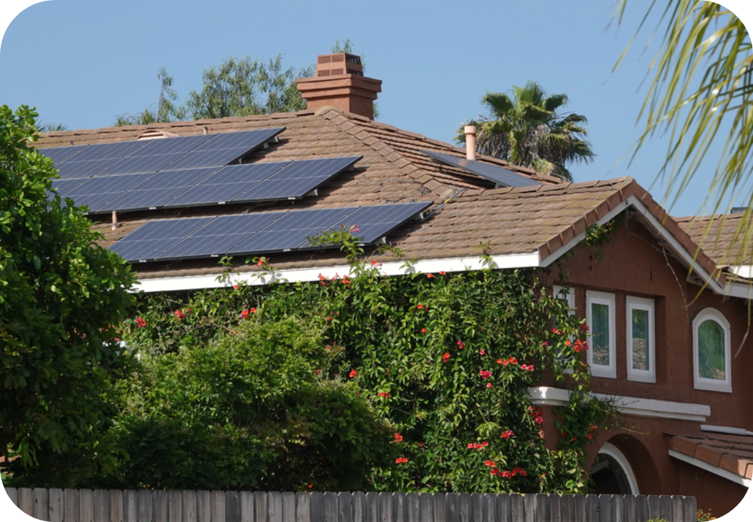 House with solar panels and vines with red flowers