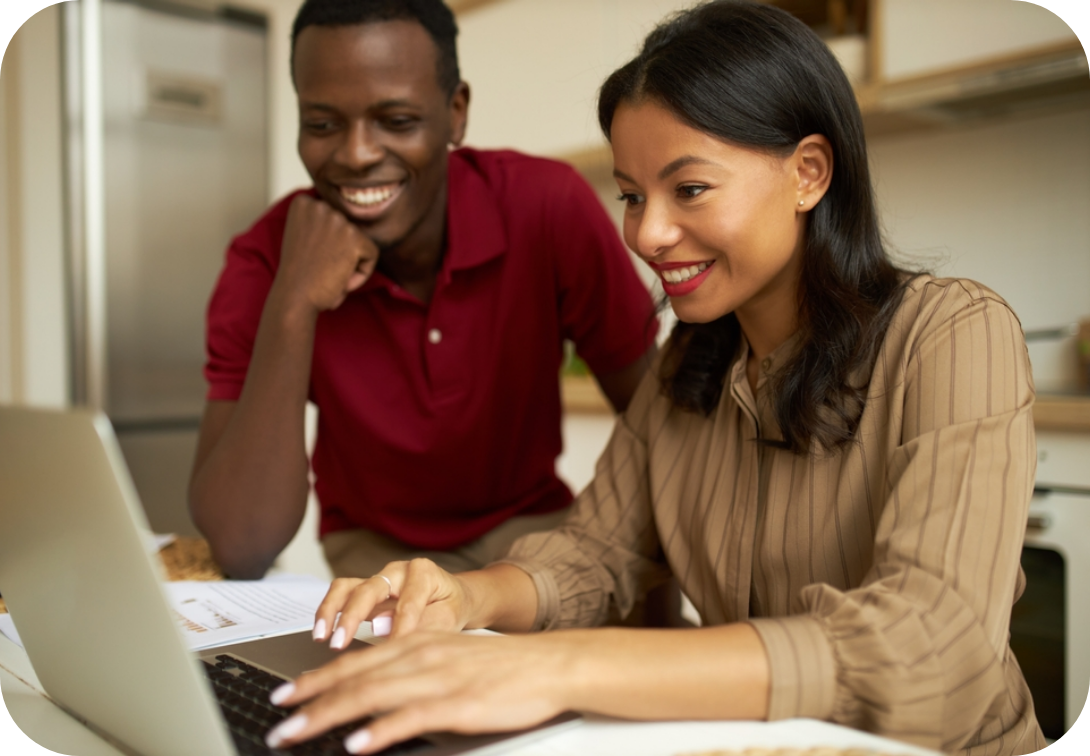 A couple looking at a laptop in the kitchen