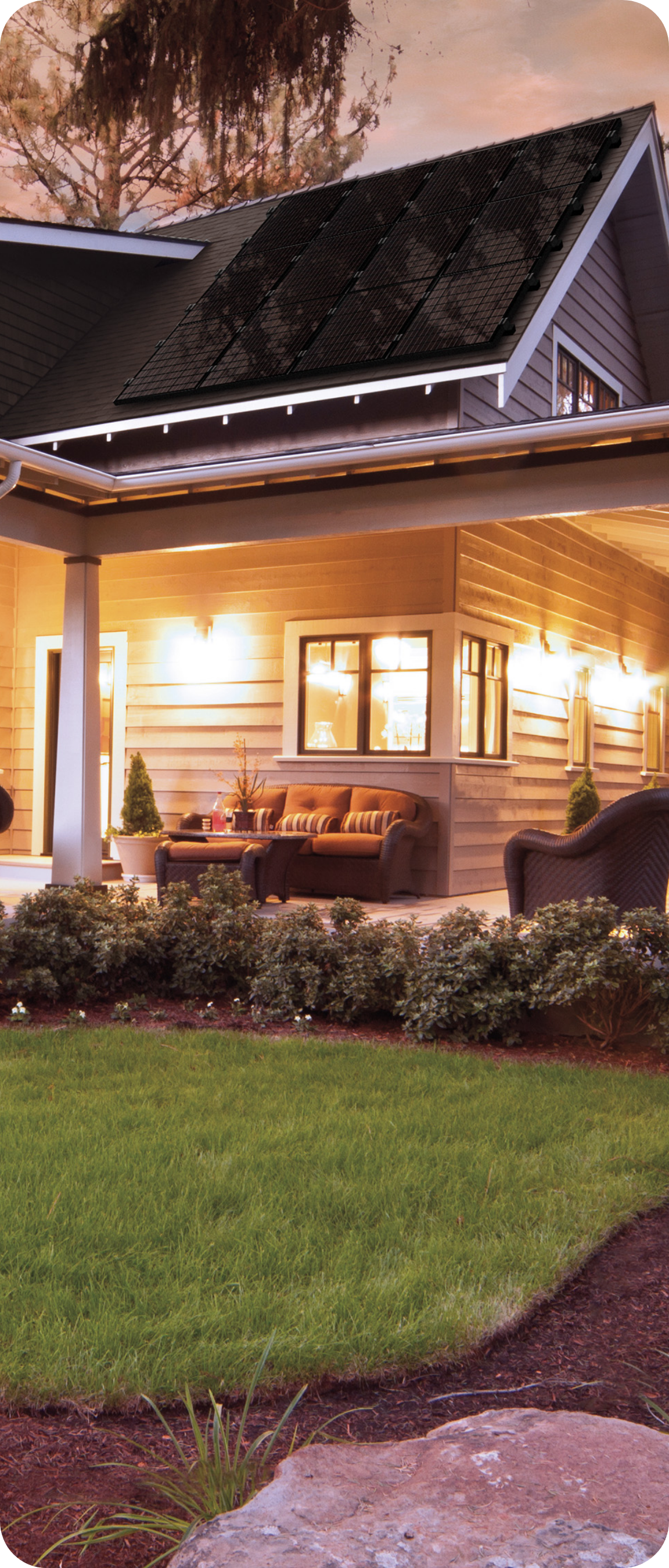 House with solar panels, porch, lights at night