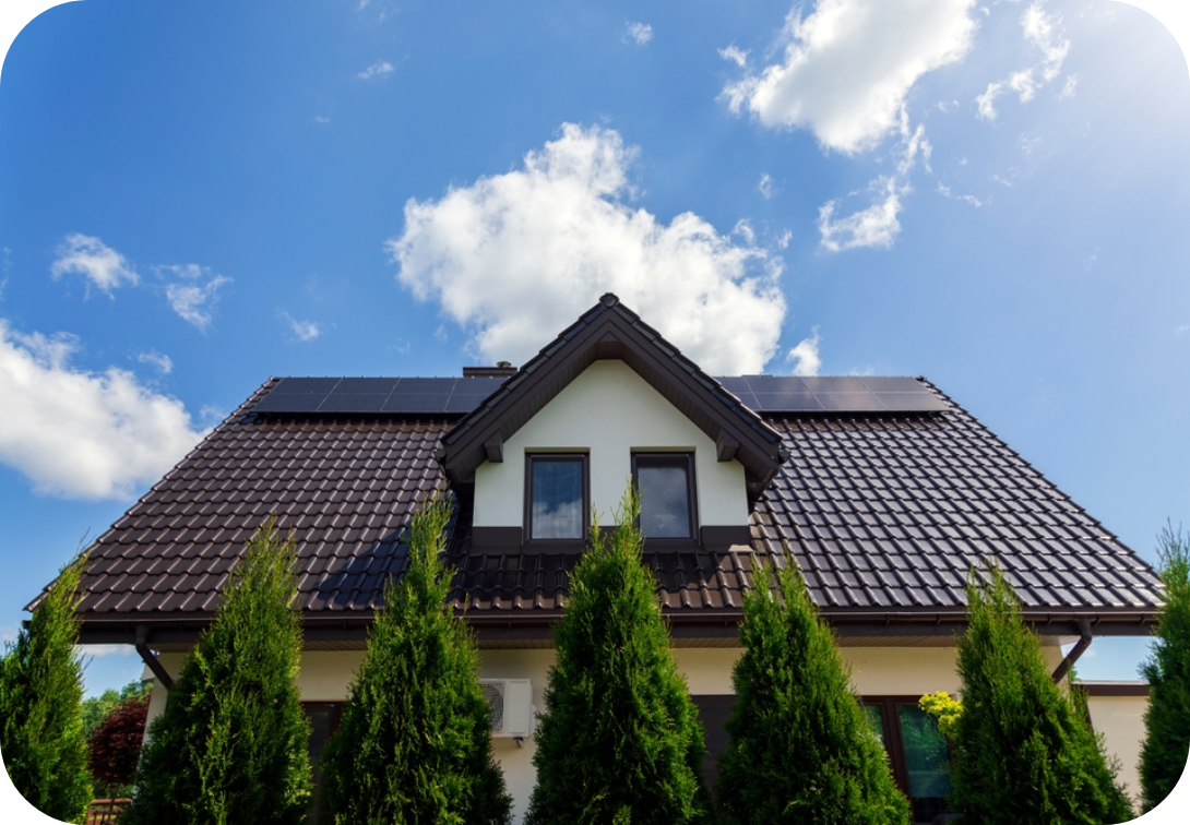 Front of a house with solar panels and trees in front