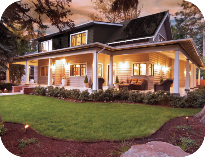 House with solar panels, porch, lights at night