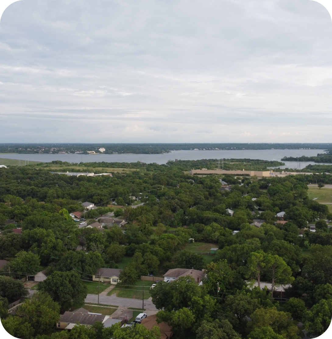 View of neighborhood with mostly trees and a lake in the background